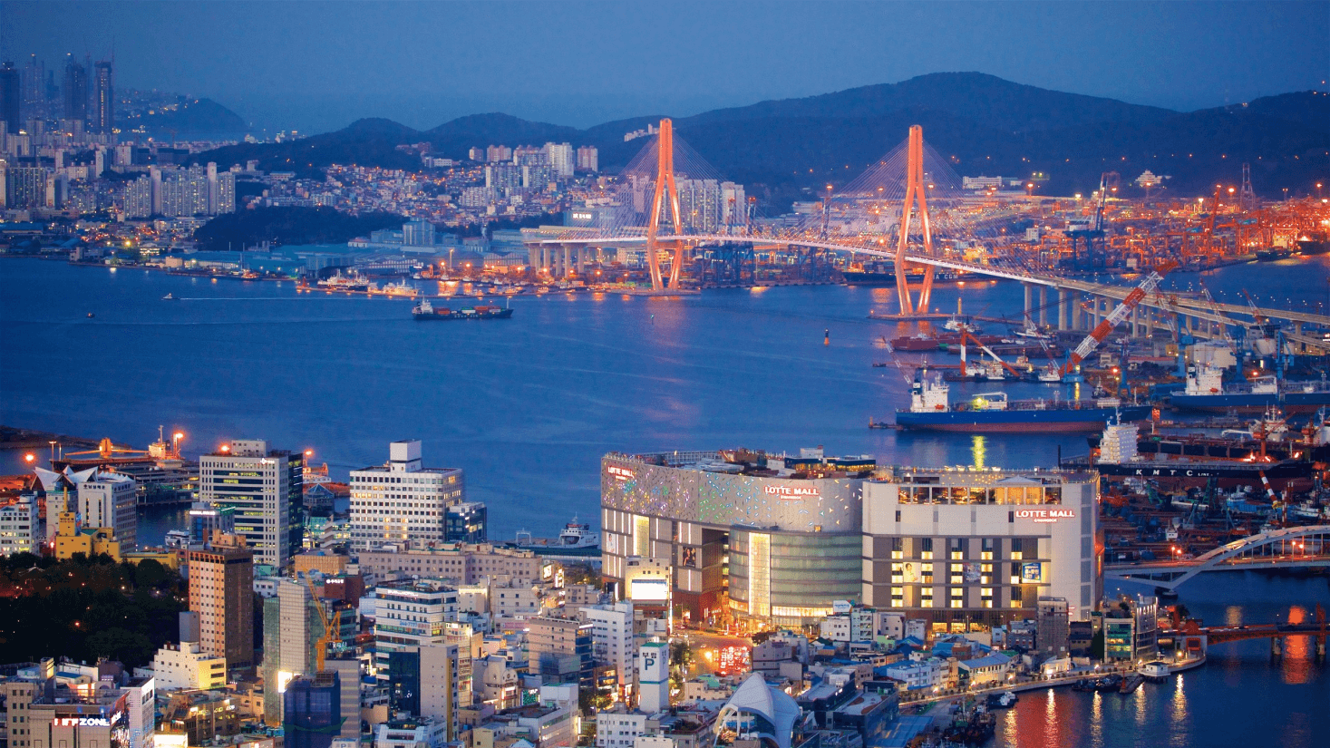 Vista panorâmica de Busan, Coreia do Sul, com montanhas e o oceano ao fundo