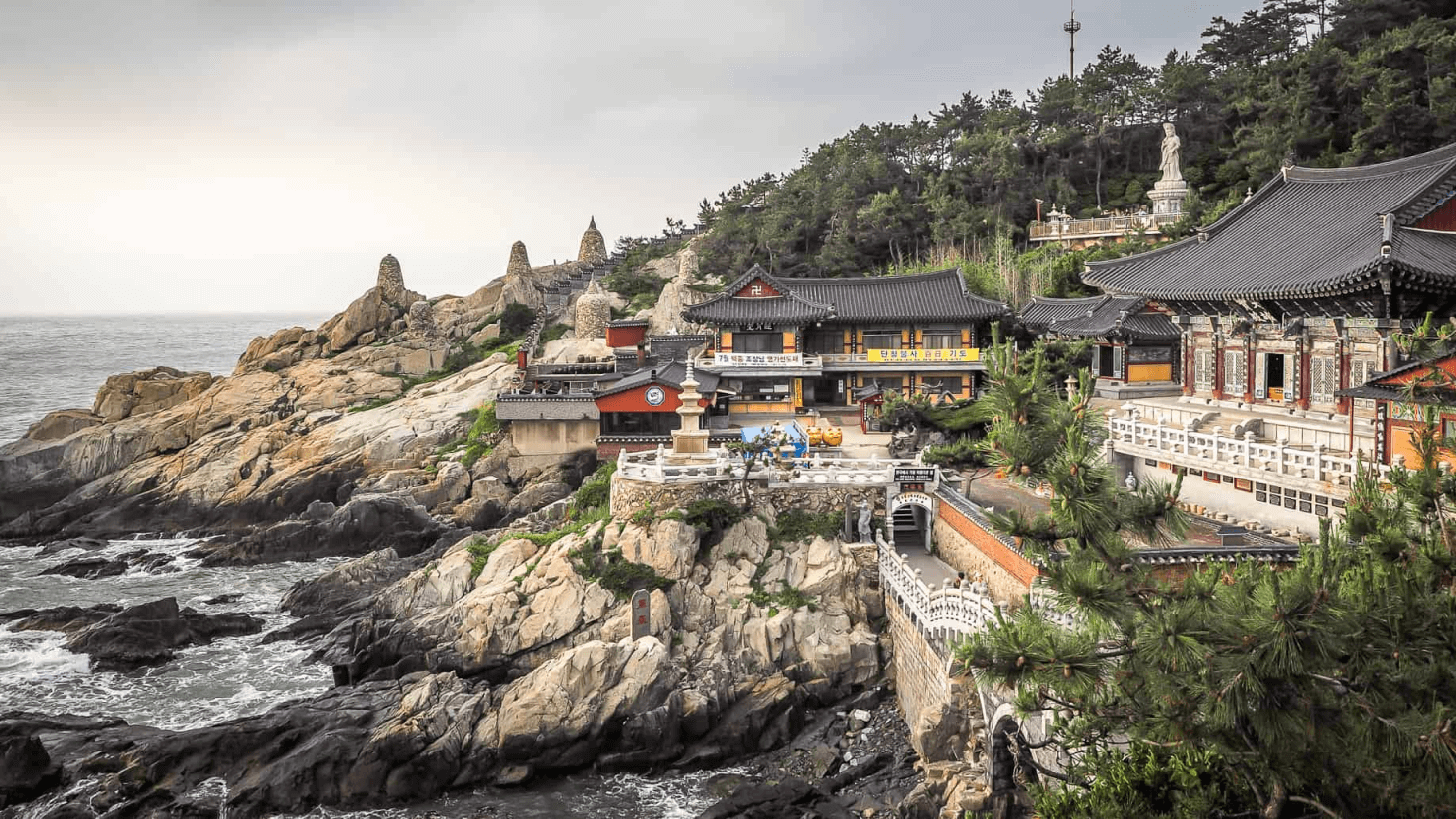 Templo Haedong Yonggungsa em Busan, Coreia do Sul, com montanhas e o oceano ao fundo